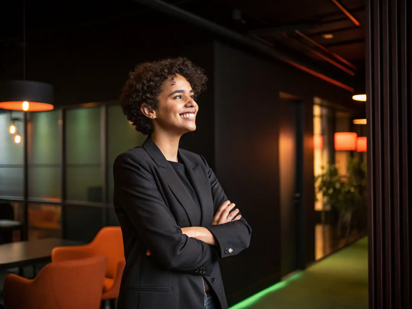 A young professional confidently answering an interview question, with a supportive and encouraging expression. The background is a modern office setting.